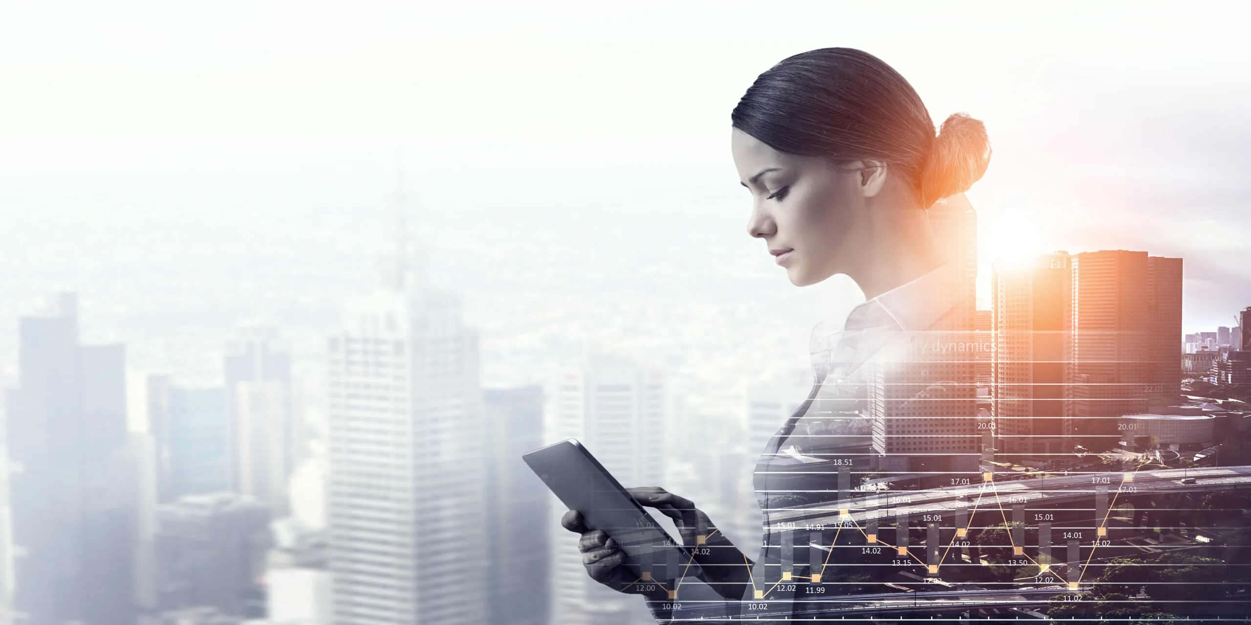 Businesswoman using a tablet against a sunlit city skyline with financial data overlays.