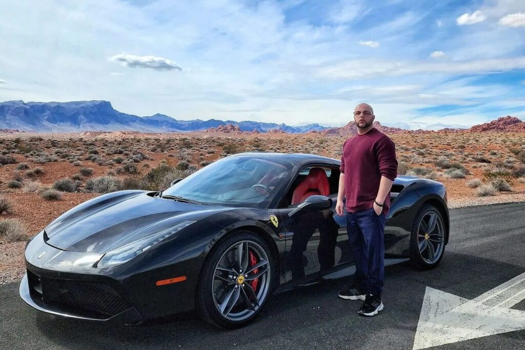 Bradlyn J. Matican | Founder Biography Landscape Bradlyn J. Matican beside his Ferrari against a desert mountain landscape